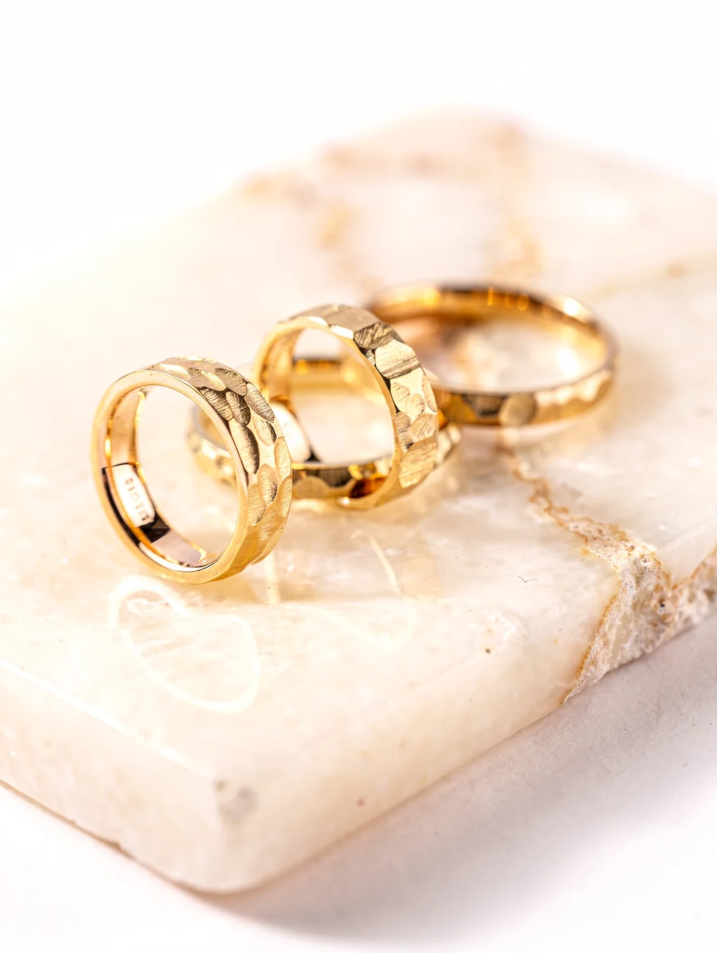 Hand-forged sterling silver rings resting on an artisan slate jeweler bench